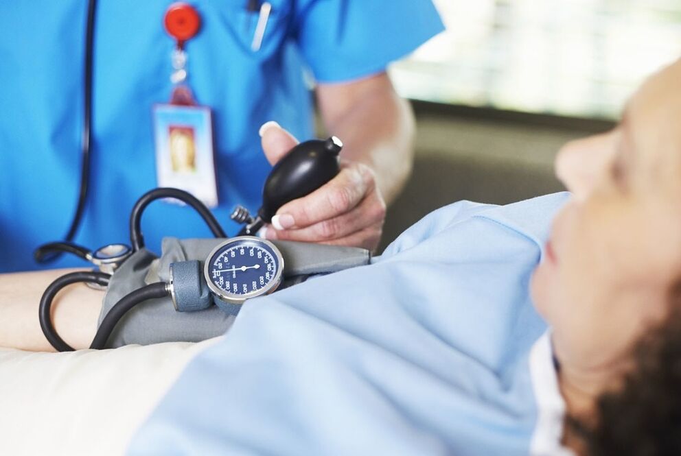 O médico mede a pressão do paciente com hipertensão